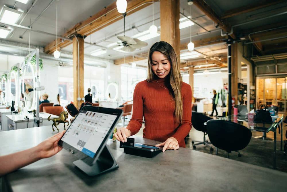 A salon client paying at the front desk